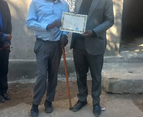 Mbaja and Pastor at the celebration with the operating partner certificate