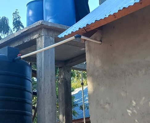 Tank stand with raw lake water tank on top, barrel sand filters in the middle and then clarified water tank on the bottom