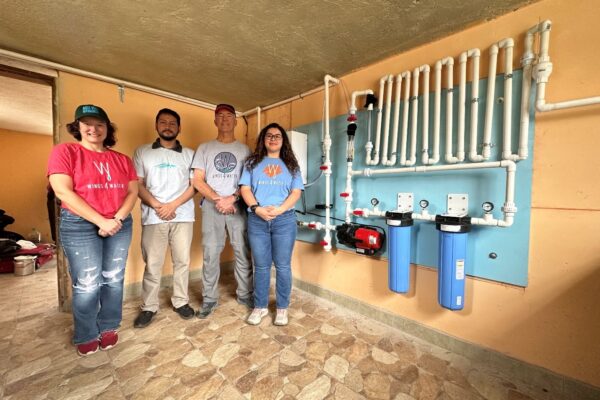 Barbara, Mario, Jerry and Keily in front of our completed water board showing off our Wings 4 Water shirts, one of our great supporters of Agua Viva