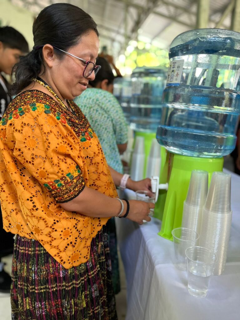 Teacher from AKT serving water