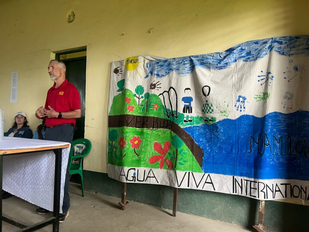Jerry in front of Ndiwa canvas on celebration day